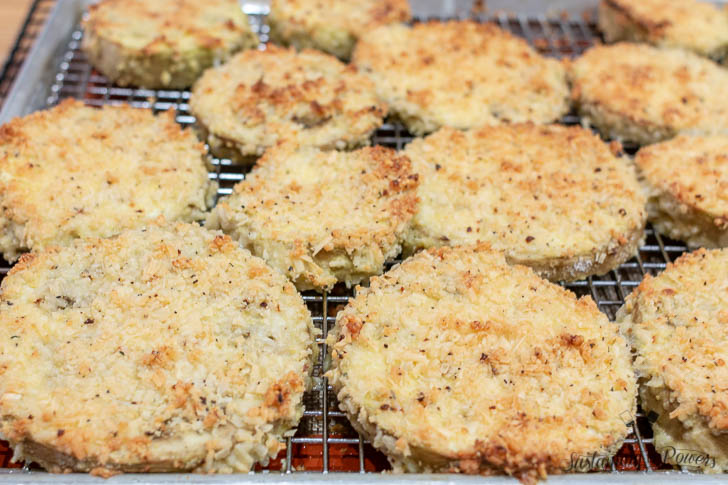 A baking tray of eggplant parmesan before cooking