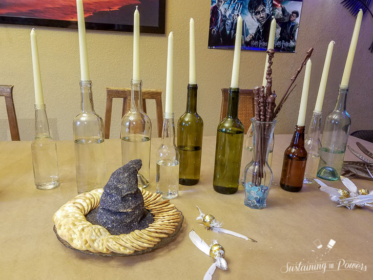 A cheese ball shaped like the sorting hat from Harry Potter, covered in poppy seeds and surrounded by crackers